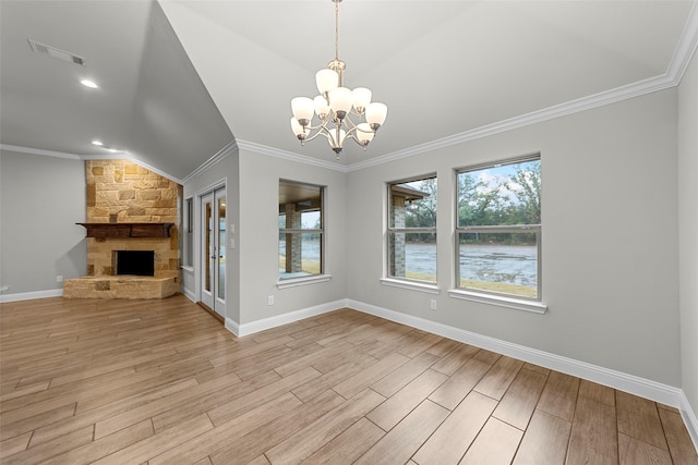 unfurnished dining area with a stone fireplace, a notable chandelier, crown molding, vaulted ceiling, and light wood-type flooring