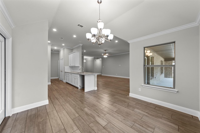 kitchen featuring sink, crown molding, pendant lighting, white cabinets, and ceiling fan with notable chandelier