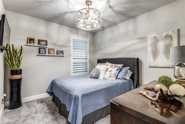 bedroom featuring light colored carpet and a notable chandelier