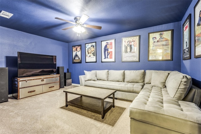 carpeted living room with a textured ceiling and ceiling fan