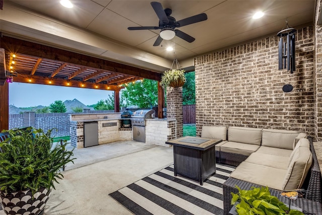 view of patio with a pergola, grilling area, ceiling fan, and exterior kitchen