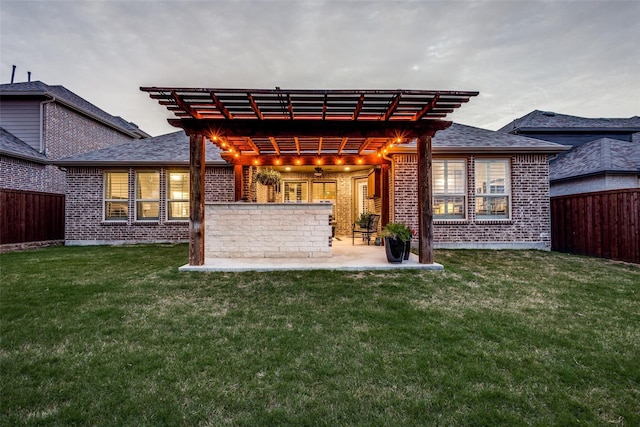 rear view of property with a pergola, a yard, and a patio