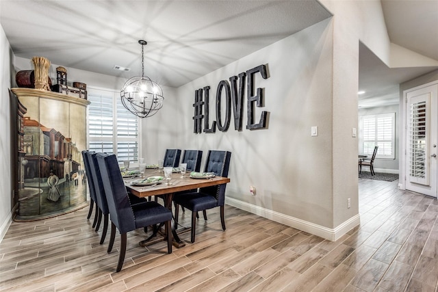 dining room with lofted ceiling and an inviting chandelier