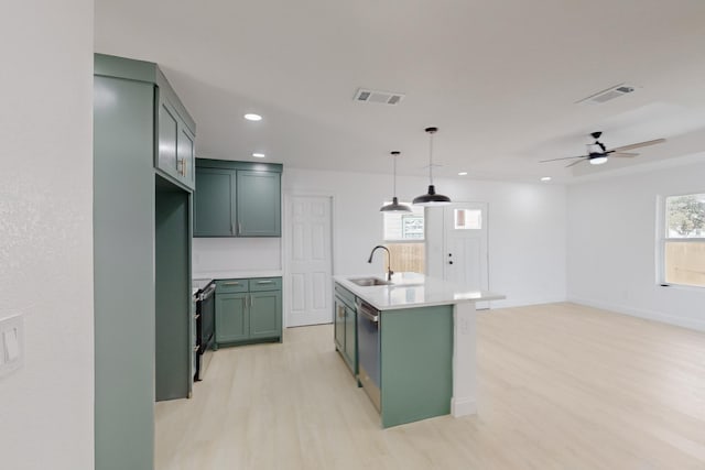 kitchen featuring a center island with sink, ceiling fan, plenty of natural light, and hanging light fixtures