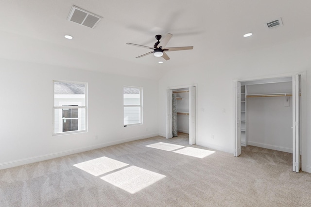 unfurnished bedroom with ceiling fan, lofted ceiling, and light carpet