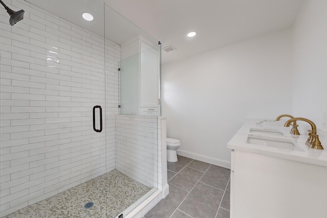 bathroom with tile patterned flooring, vanity, a shower with door, and toilet