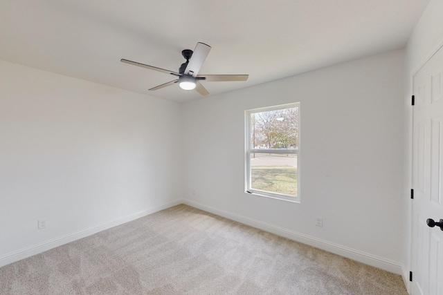 carpeted spare room featuring ceiling fan