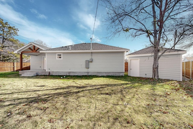 rear view of property with an outdoor structure and a lawn