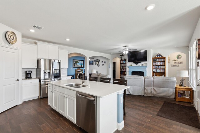 kitchen with white cabinets, sink, a kitchen island with sink, and stainless steel appliances