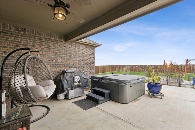 view of patio with a playground and a hot tub