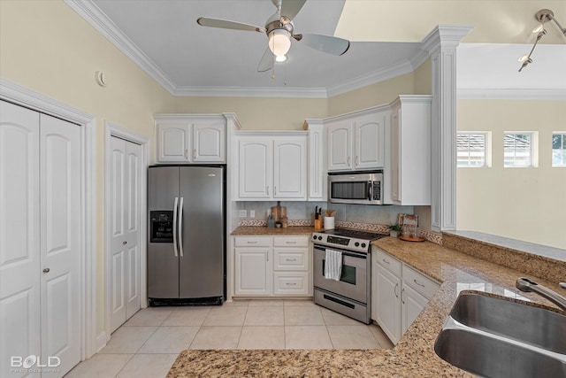 kitchen with white cabinetry, appliances with stainless steel finishes, light tile patterned flooring, crown molding, and sink