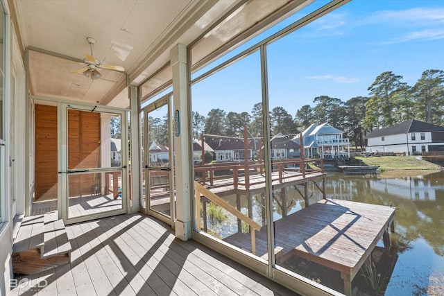 sunroom / solarium with a water view, ceiling fan, and a wealth of natural light