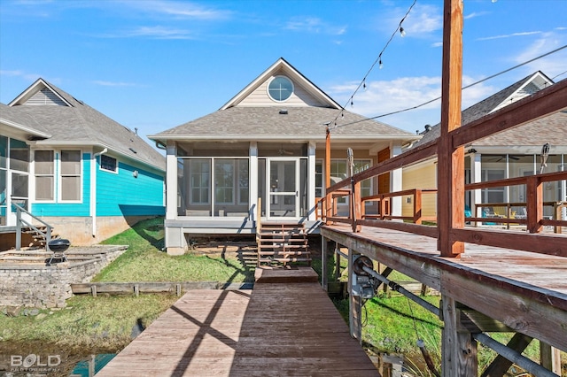 rear view of house with a deck and a sunroom