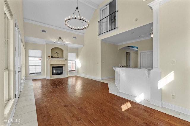 unfurnished living room featuring light hardwood / wood-style floors, beamed ceiling, crown molding, high vaulted ceiling, and ceiling fan with notable chandelier