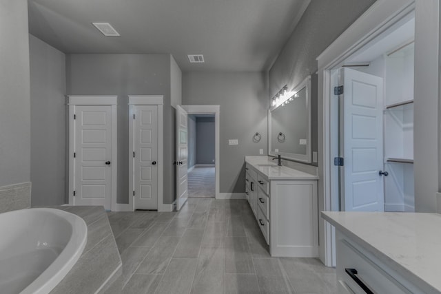 bathroom with vanity and a washtub