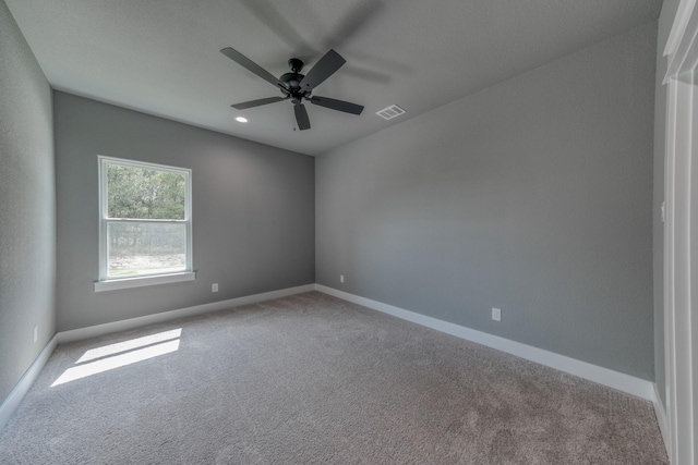 empty room with ceiling fan and light carpet