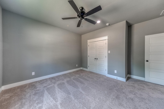 unfurnished bedroom featuring ceiling fan, light carpet, and a closet