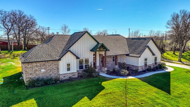 modern farmhouse style home with brick siding, board and batten siding, and a shingled roof