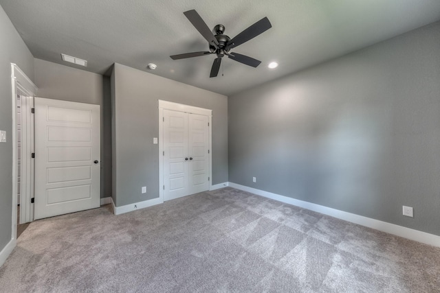 unfurnished bedroom with light carpet, a closet, and ceiling fan