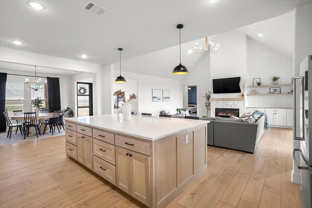 kitchen with a fireplace, pendant lighting, and a notable chandelier