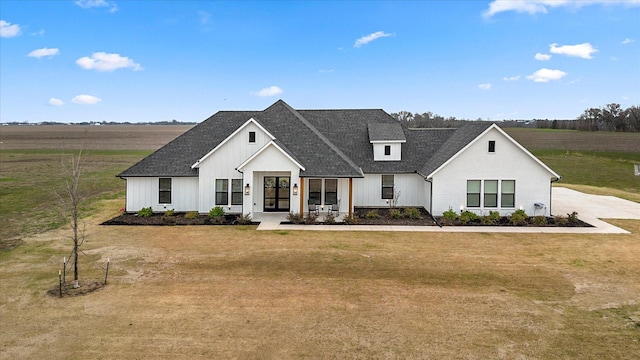 modern farmhouse style home with a front lawn and a rural view