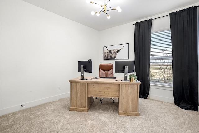 carpeted home office featuring an inviting chandelier