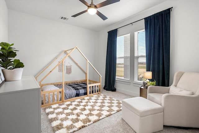 bedroom with multiple windows, ceiling fan, and light carpet