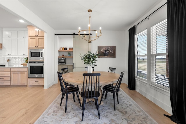 dining space featuring a chandelier and light hardwood / wood-style flooring