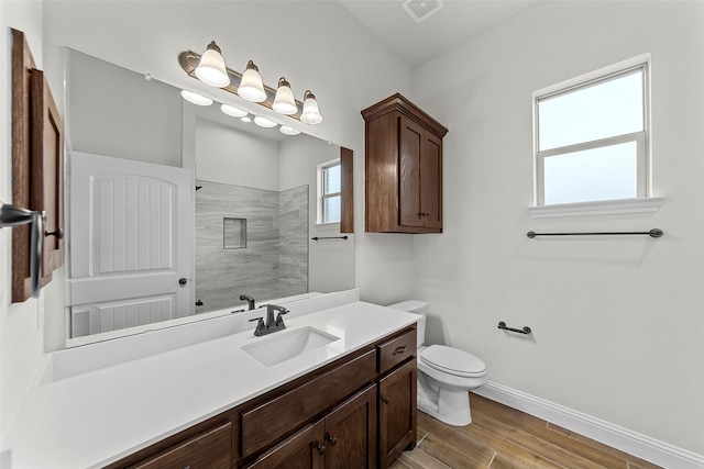 bathroom with vanity, hardwood / wood-style floors, toilet, and a shower