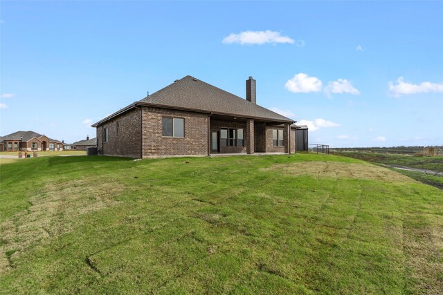 rear view of house featuring a lawn