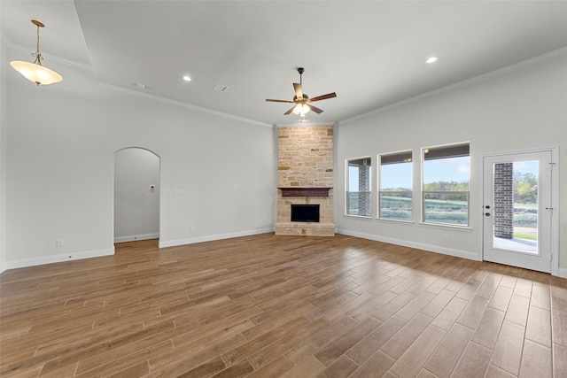 unfurnished living room with a fireplace, ceiling fan, and crown molding