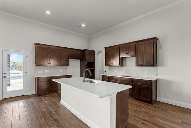 kitchen featuring sink, crown molding, dark hardwood / wood-style flooring, an island with sink, and black electric stovetop