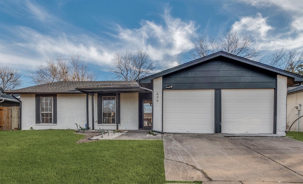 ranch-style house featuring a garage and a front lawn