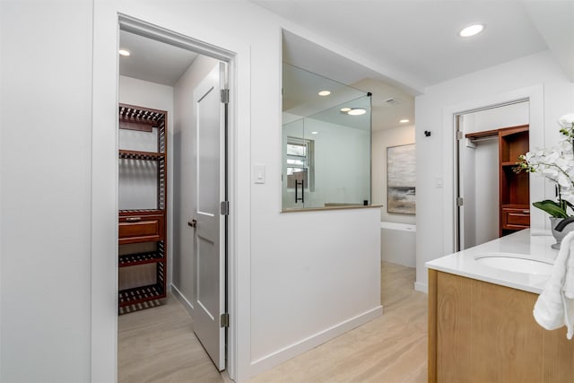 hallway with light hardwood / wood-style floors and sink