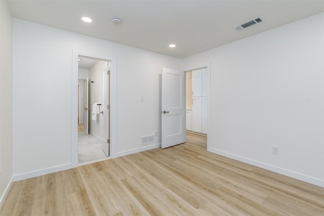 unfurnished bedroom with a closet and light wood-type flooring