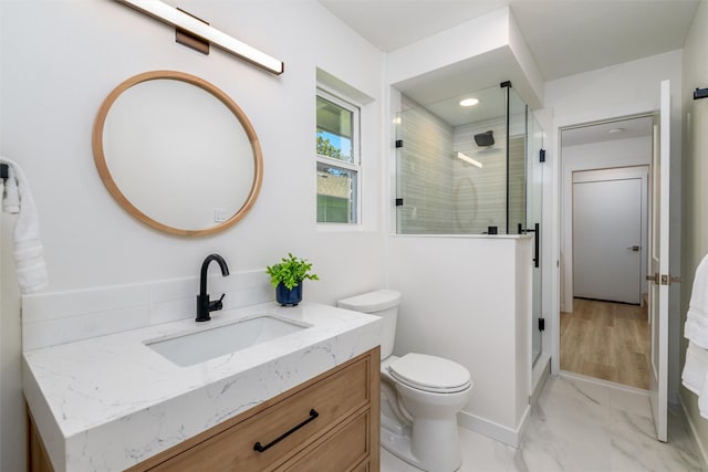 bathroom with toilet, vanity, and walk in shower