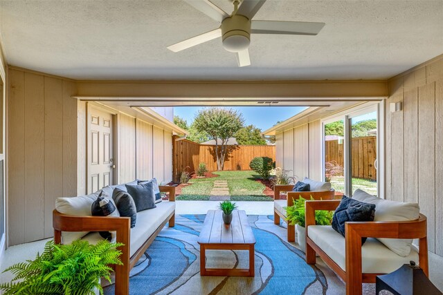 sunroom / solarium featuring ceiling fan