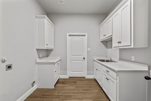 laundry room with electric dryer hookup, sink, and cabinets