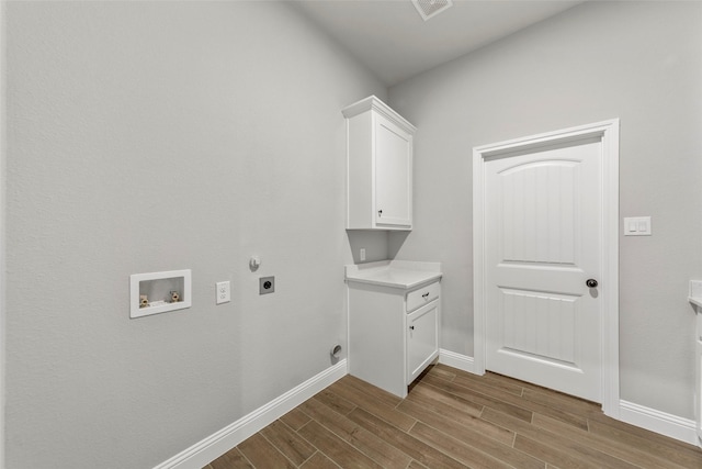 washroom with cabinets, wood-type flooring, electric dryer hookup, and washer hookup