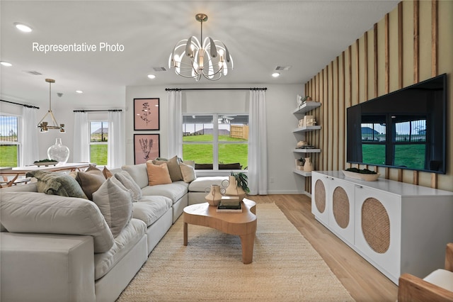 living room with light hardwood / wood-style flooring and a notable chandelier