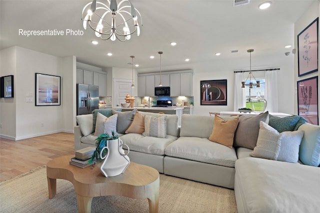 living room with light wood-type flooring and a notable chandelier