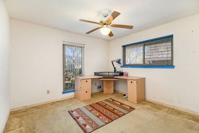 carpeted office space featuring a wealth of natural light and ceiling fan