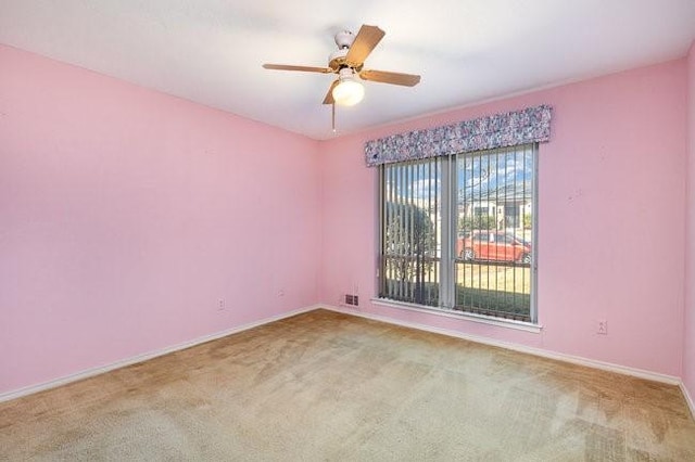 carpeted spare room with ceiling fan