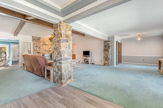 living room with crown molding, beam ceiling, a fireplace, and hardwood / wood-style flooring