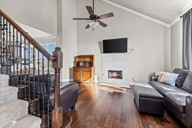 living room featuring high vaulted ceiling, ceiling fan, ornamental molding, a fireplace, and dark hardwood / wood-style flooring