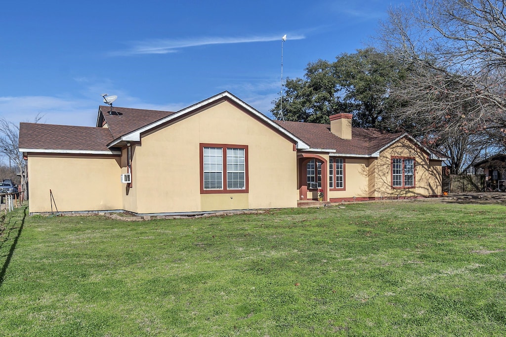 rear view of house featuring a yard