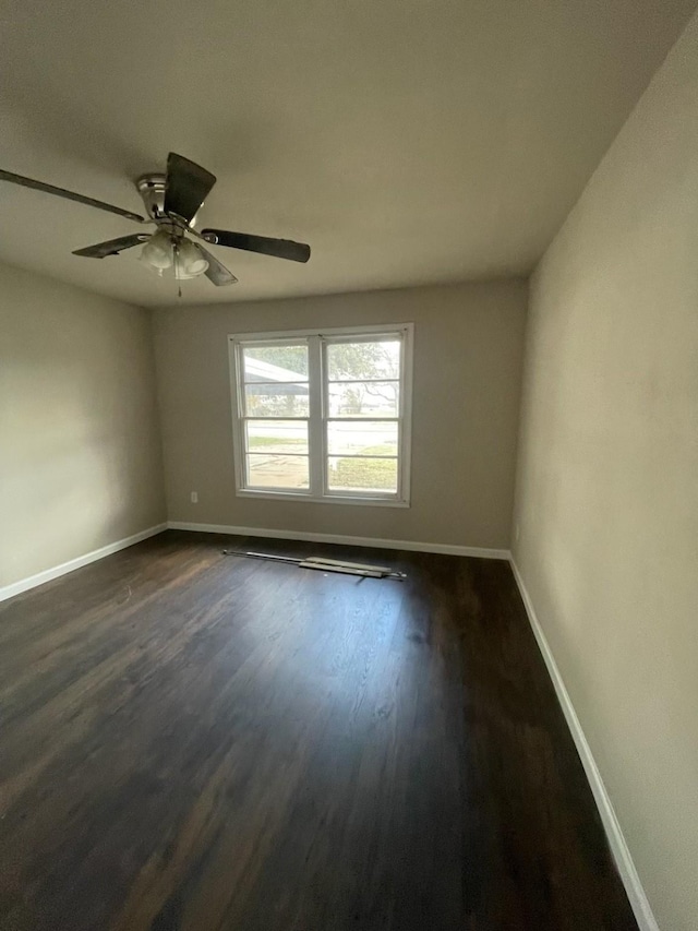 empty room with ceiling fan and dark hardwood / wood-style flooring