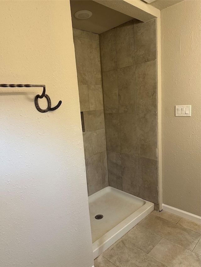 bathroom featuring tile patterned flooring and tiled shower