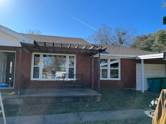 view of front of property featuring a garage and a pergola