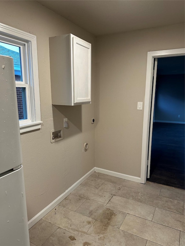 clothes washing area featuring cabinets and light tile patterned flooring